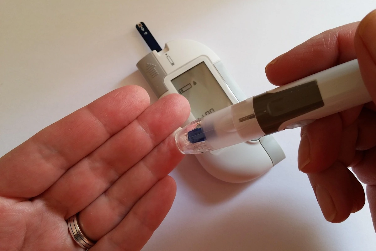 Blutzuckermessung mit Stechhilfe am Finger.